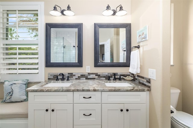 full bath featuring toilet, a sink, and double vanity
