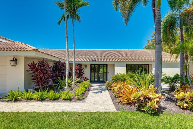 526 Bird Key Dr, Sarasota, FL 34236 - view of front of home with french doors, a tiled roof, and stucco siding