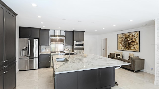 526 Bird Key Dr, Sarasota, FL 34236 - kitchen with stainless steel appliances, a sink, a kitchen island with sink, ornamental molding, and light stone counters