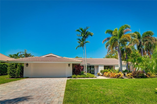 526 Bird Key Dr, Sarasota, FL 34236 - ranch-style house with a tiled roof, a front lawn, an attached garage, and stucco siding