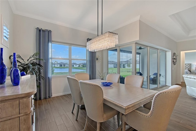 dining room featuring ornamental molding, a water view, and wood finished floors