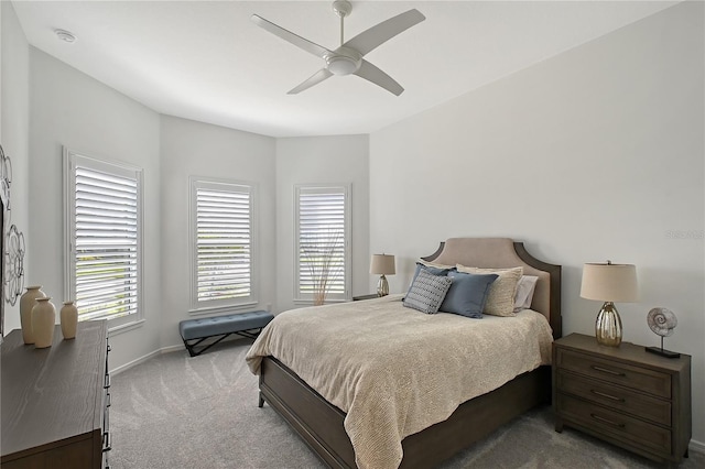 bedroom with a ceiling fan, multiple windows, light carpet, and baseboards