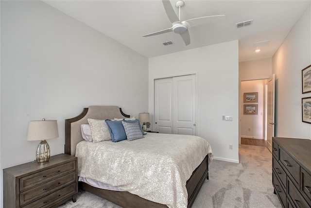 bedroom featuring light colored carpet, a closet, visible vents, and baseboards