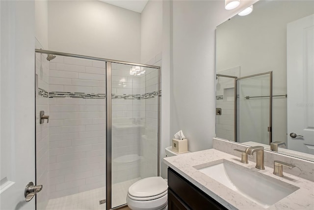 full bathroom featuring a shower stall, toilet, and vanity