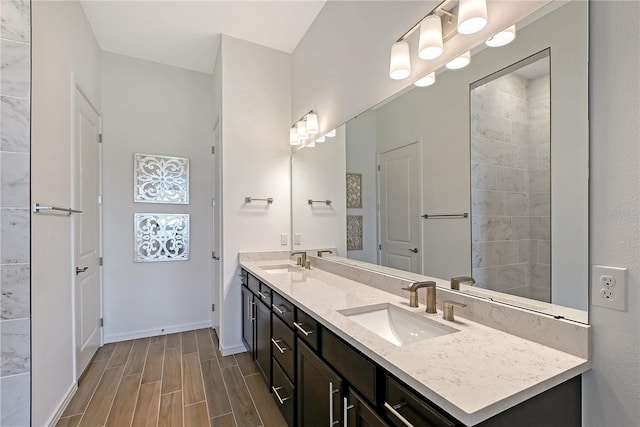 full bathroom with wood tiled floor, a sink, baseboards, and double vanity