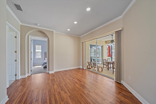 spare room featuring crown molding and wood-type flooring