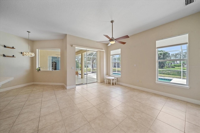 spare room with ceiling fan, light tile patterned floors, and a textured ceiling