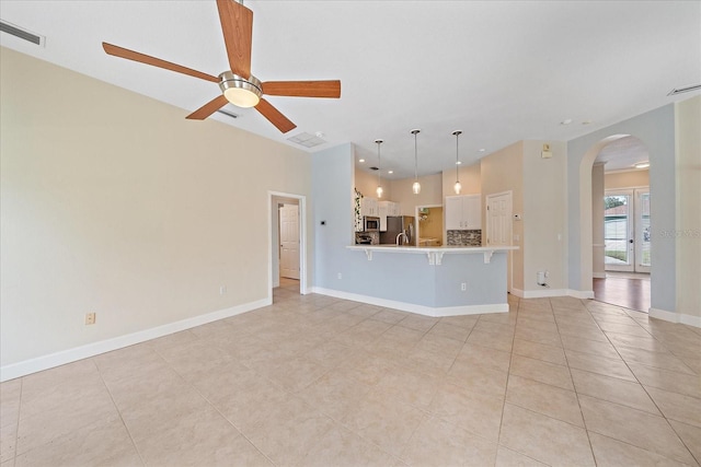 unfurnished living room featuring ceiling fan and light tile patterned floors