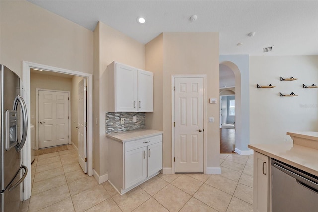 kitchen with light tile patterned floors, stainless steel appliances, and white cabinetry