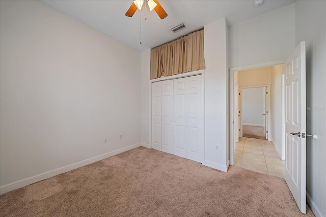 unfurnished bedroom featuring light carpet, ceiling fan, and a closet