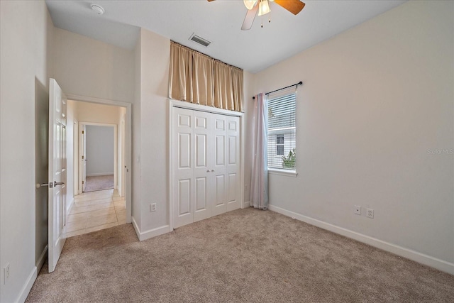 unfurnished bedroom with ceiling fan, a closet, and light colored carpet