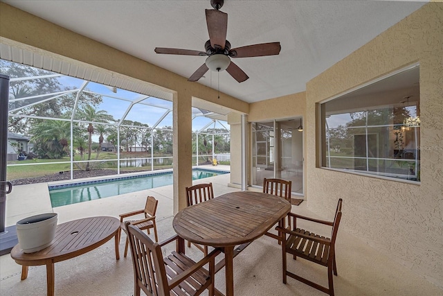 sunroom featuring ceiling fan and a pool