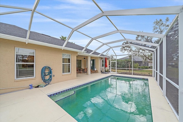 view of pool featuring a patio, ceiling fan, and glass enclosure