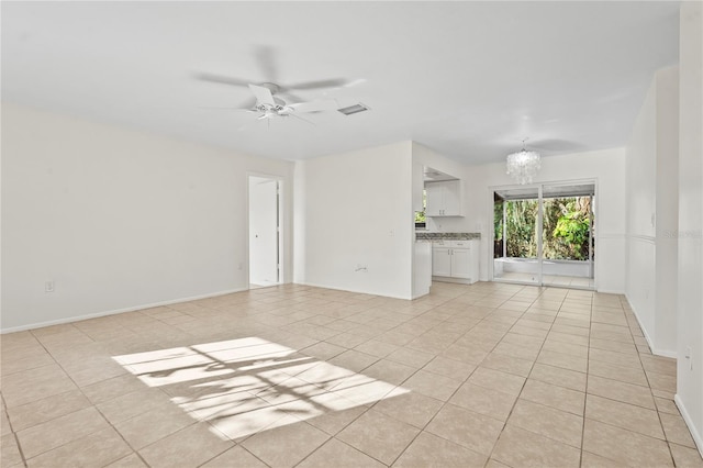 unfurnished living room featuring light tile patterned floors, visible vents, baseboards, and ceiling fan with notable chandelier