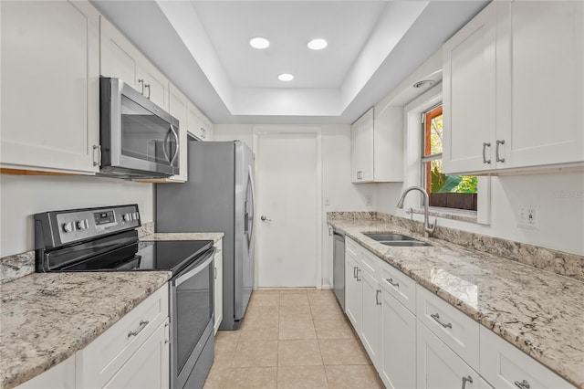 kitchen featuring stainless steel appliances, white cabinetry, a sink, and light tile patterned floors