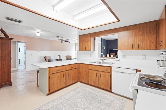 kitchen with light countertops, white appliances, a sink, and visible vents