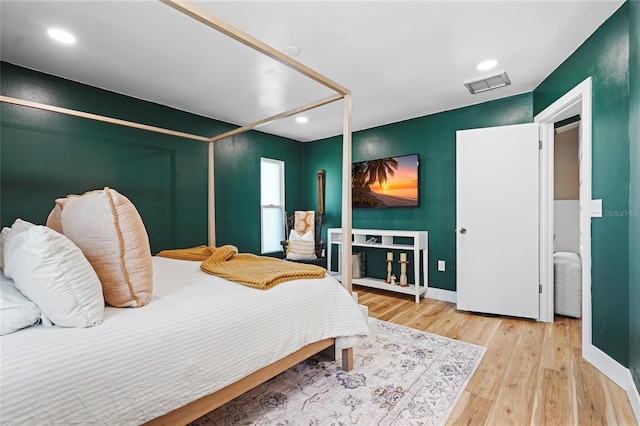 bedroom featuring baseboards, visible vents, wood finished floors, and recessed lighting