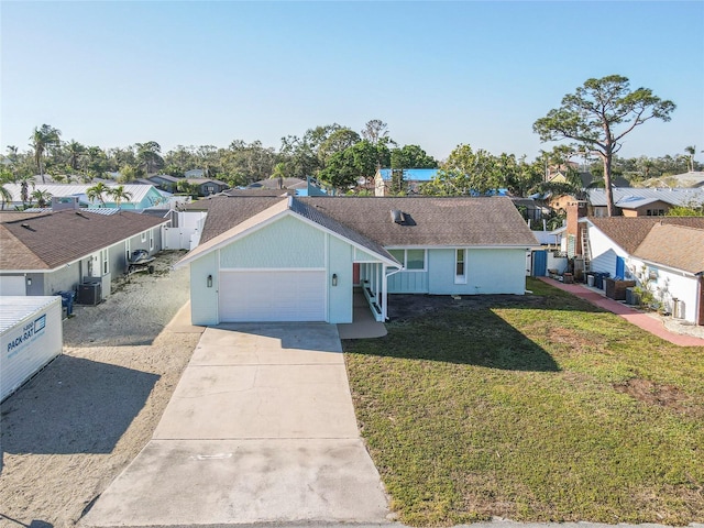 single story home with driveway, an attached garage, a residential view, and a front yard