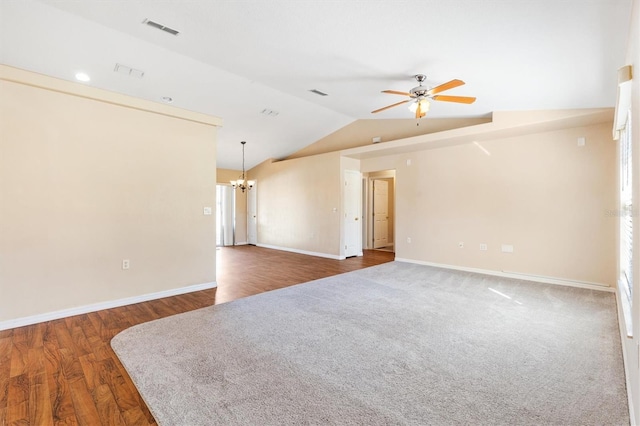 spare room with baseboards, visible vents, dark wood-style floors, vaulted ceiling, and ceiling fan with notable chandelier