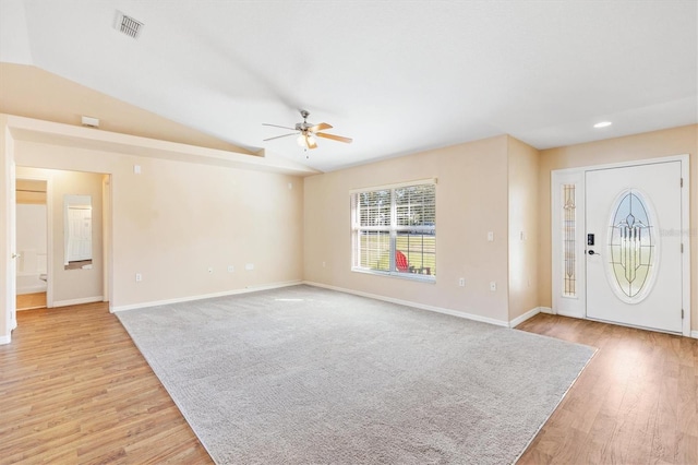 foyer entrance with light wood-type flooring, vaulted ceiling, and baseboards