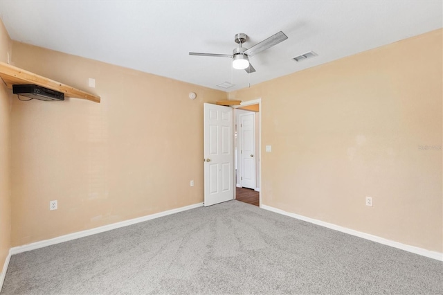 empty room featuring a ceiling fan, carpet, visible vents, and baseboards