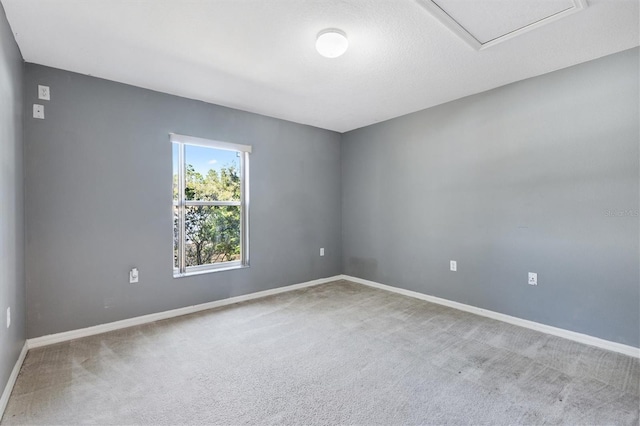 carpeted empty room featuring baseboards