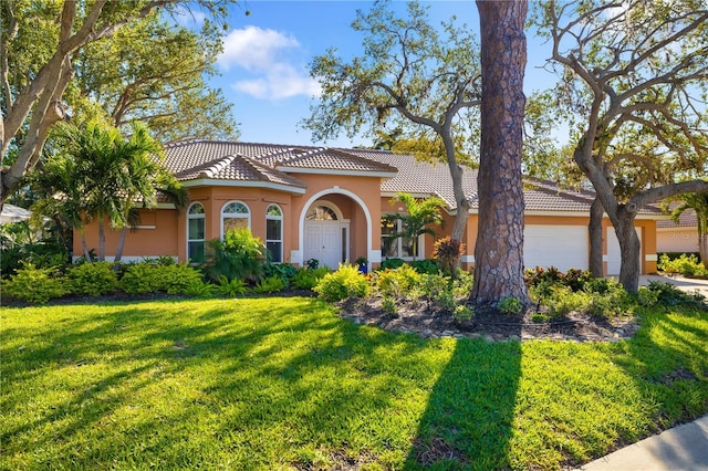 mediterranean / spanish house featuring a garage, stucco siding, a tile roof, and a front yard