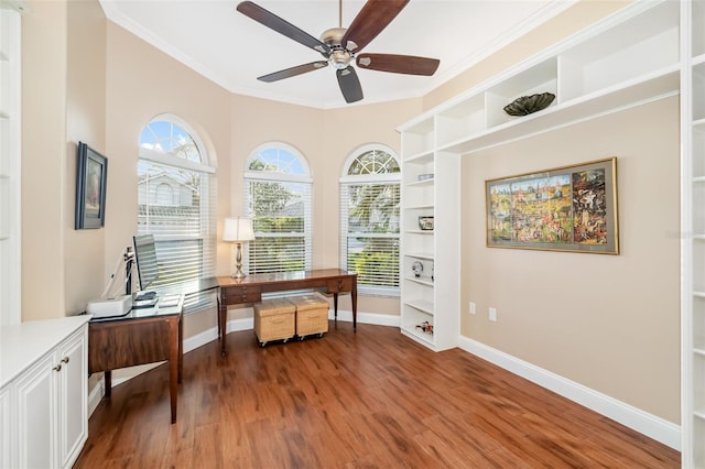 office area featuring plenty of natural light, built in shelves, baseboards, and wood finished floors