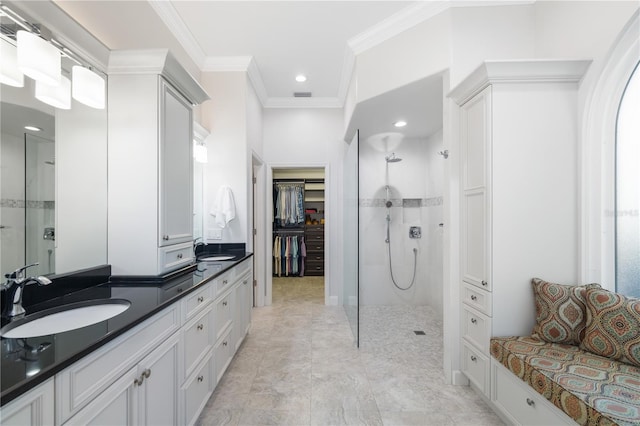 full bathroom featuring visible vents, tiled shower, vanity, and crown molding