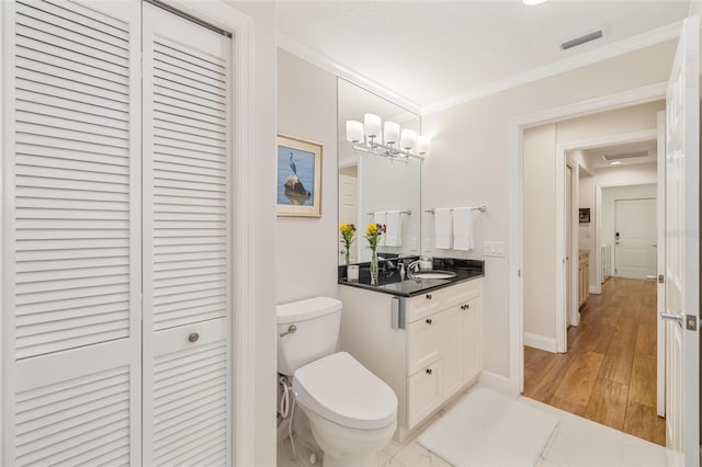 bathroom with visible vents, crown molding, toilet, a closet, and vanity