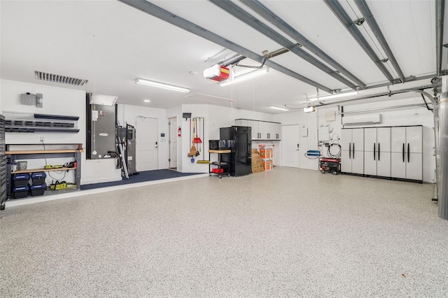 garage with visible vents, a garage door opener, and freestanding refrigerator