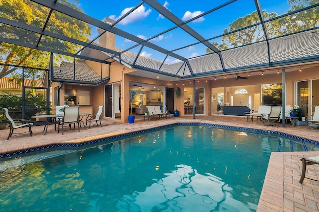 pool with an outdoor hangout area, a lanai, a ceiling fan, and a patio area