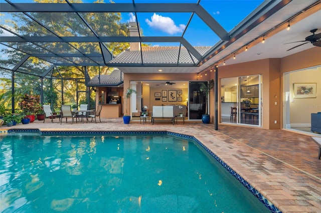 outdoor pool featuring a ceiling fan, an outdoor living space, glass enclosure, and a patio area