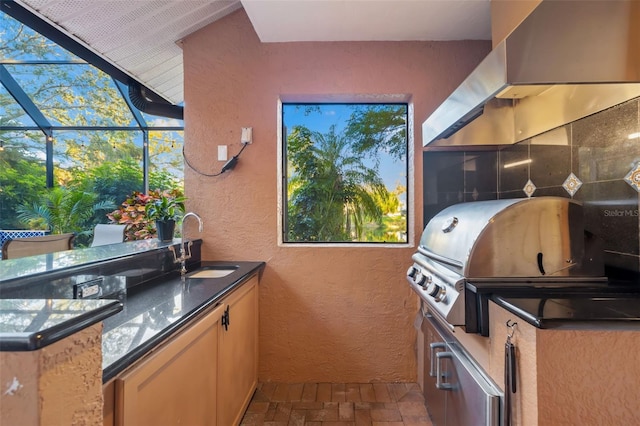 view of patio / terrace with a sink, glass enclosure, area for grilling, and an outdoor kitchen