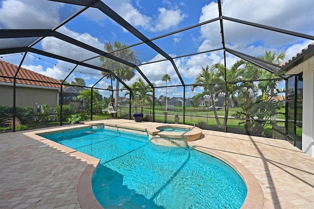 view of pool with glass enclosure, a patio area, and a pool with connected hot tub