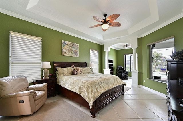 bedroom featuring light tile patterned floors, baseboards, ornate columns, a raised ceiling, and crown molding