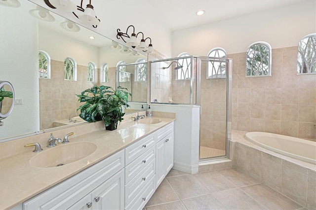 bathroom with tile patterned flooring, a sink, a shower stall, and double vanity