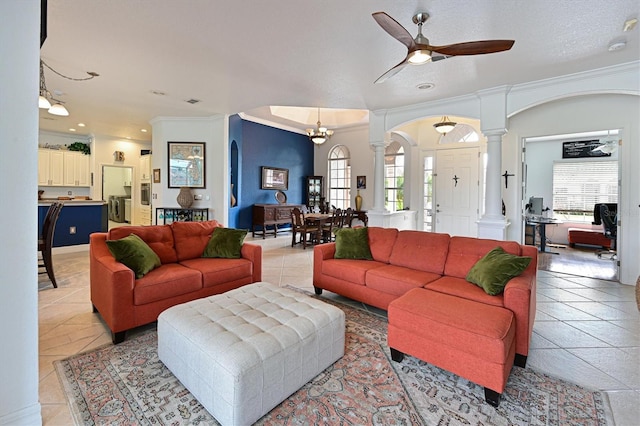 living room with arched walkways, ornamental molding, light tile patterned floors, and ornate columns