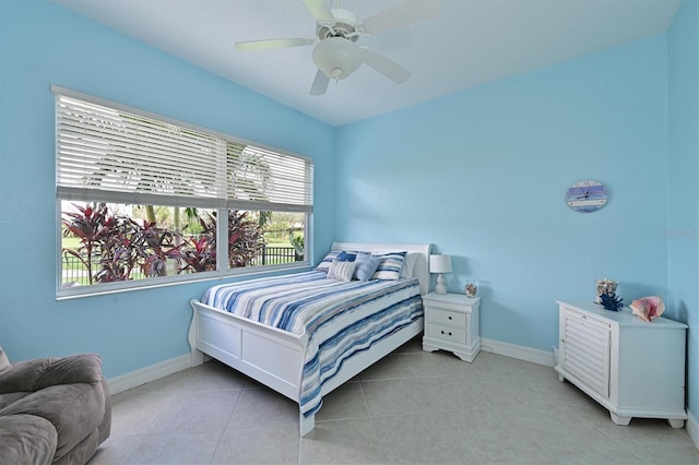 bedroom with light tile patterned floors, a ceiling fan, and baseboards