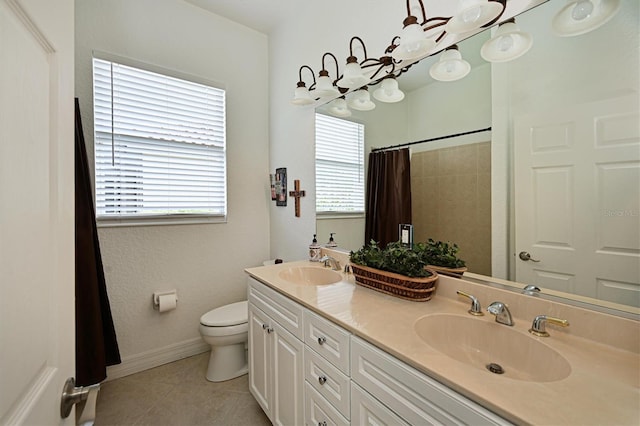 full bathroom with toilet, double vanity, a sink, and tile patterned floors