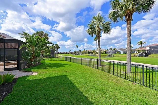 view of yard featuring glass enclosure and fence