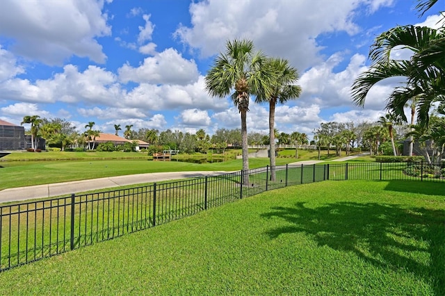 view of community with a lawn and fence