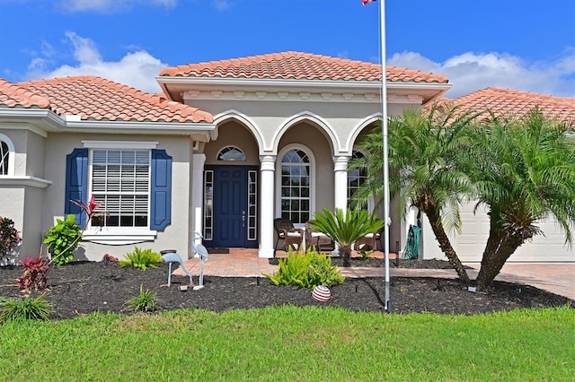 exterior space with an attached garage, driveway, a tiled roof, and stucco siding