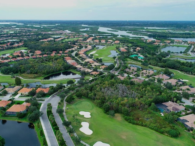 drone / aerial view with a residential view, a water view, and golf course view