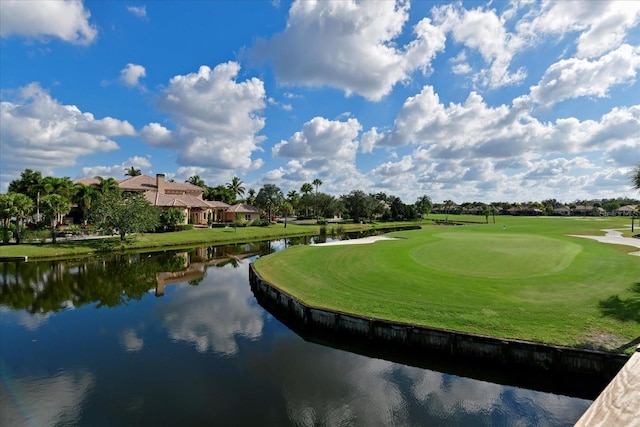 view of home's community featuring view of golf course, a lawn, and a water view