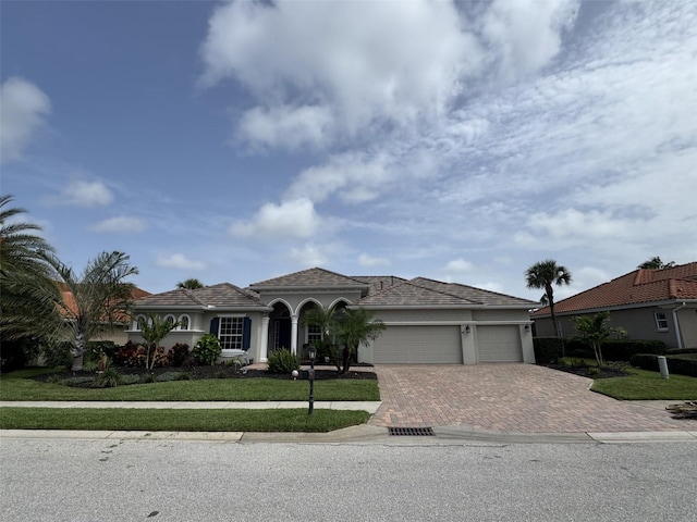 10509 Winding Stream Way, Bradenton, FL 34212 - view of front of home featuring decorative driveway, an attached garage, a front yard, and stucco siding