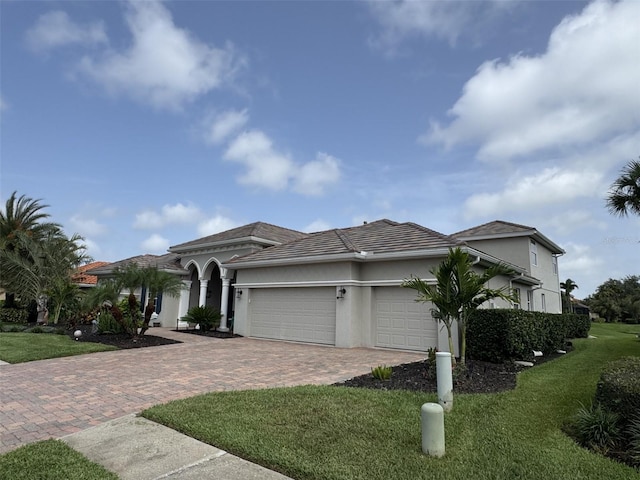 10509 Winding Stream Way, Bradenton, FL 34212 - view of front of house with decorative driveway, an attached garage, a front yard, stucco siding, and a tile roof