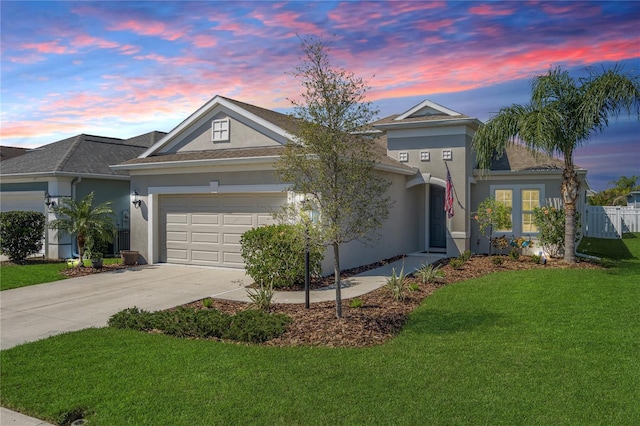 ranch-style house with a garage, concrete driveway, a front lawn, and stucco siding