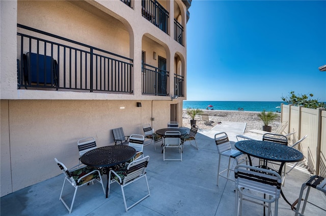 view of patio featuring a view of the beach and a water view