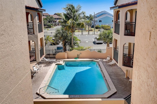 pool featuring a residential view, a patio area, and fence